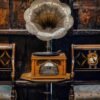 A captivating vintage gramophone surrounded by classic wooden chairs in an antique setting.