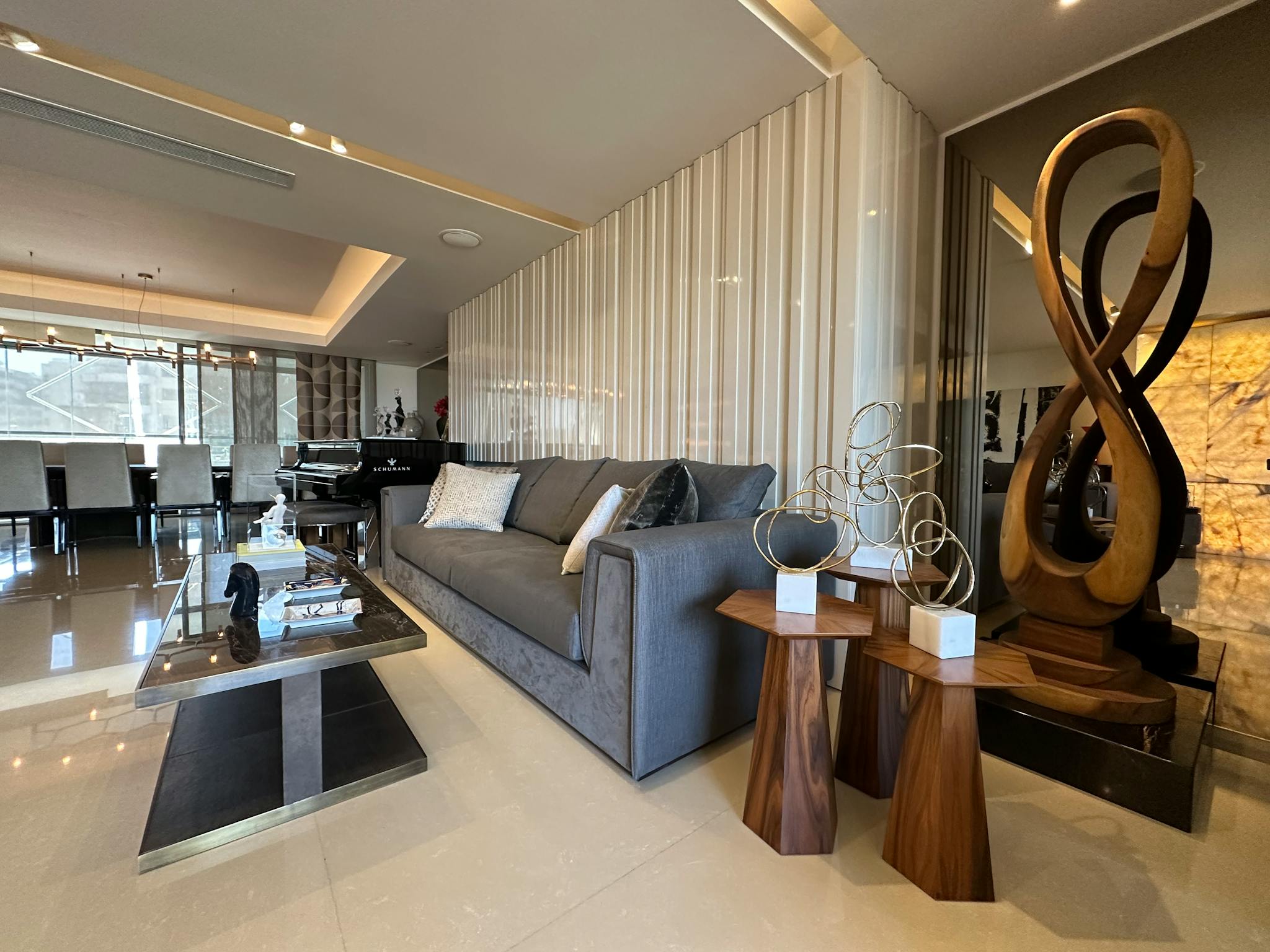 Spacious modern living room featuring elegant decor and unique sculptures, capturing a sense of luxury and style.